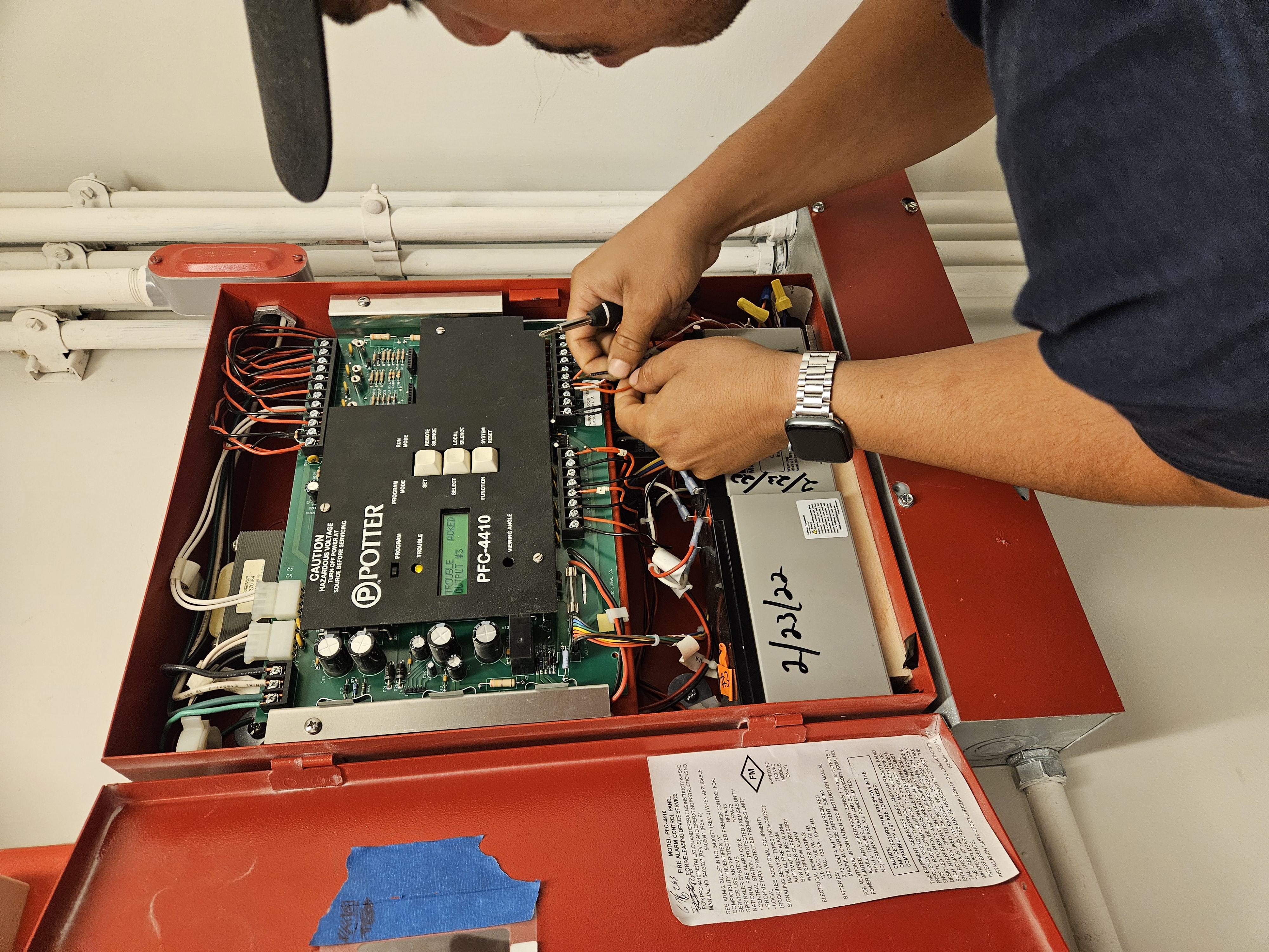 A fire protection professional working on a panel